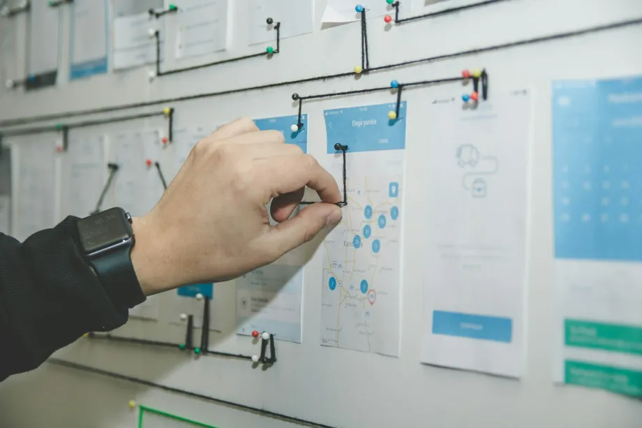 Person arranging paper cards and notes on a planning board