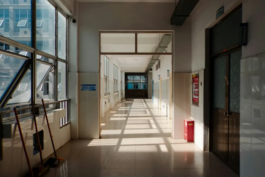 Long empty hallway with sunlight casting shadows across the floor